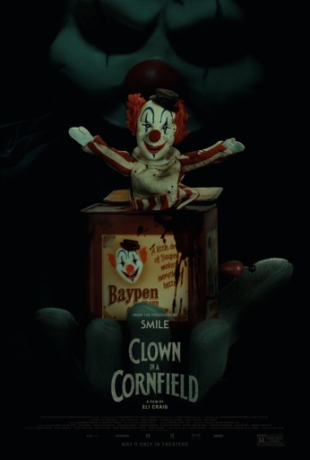 A dark poster for Clown in a Cornfield shows a bloodstained jack-in-the-box clown doll with red hair, a painted white face, striped clothes, and a tiny brown hat. The box reads “Baypen” with a slogan, “A little drop of Baypen makes everything better,” and is spattered with blood. Behind it looms the shadowy, menacing face of a full-sized clown with a red nose and black makeup streaks. At the bottom, the tagline reads “From the producers of Smile,” with the film’s title, director Eli Craig’s name, and the release date: May 9, only in theaters.